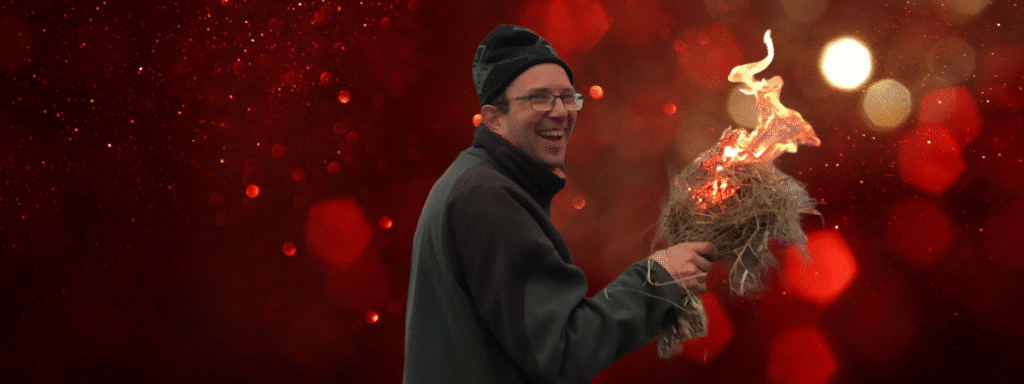 Christmas Gift Ideas for Him - Happy Man smiling with flaming tinder bundle and Christmas Background