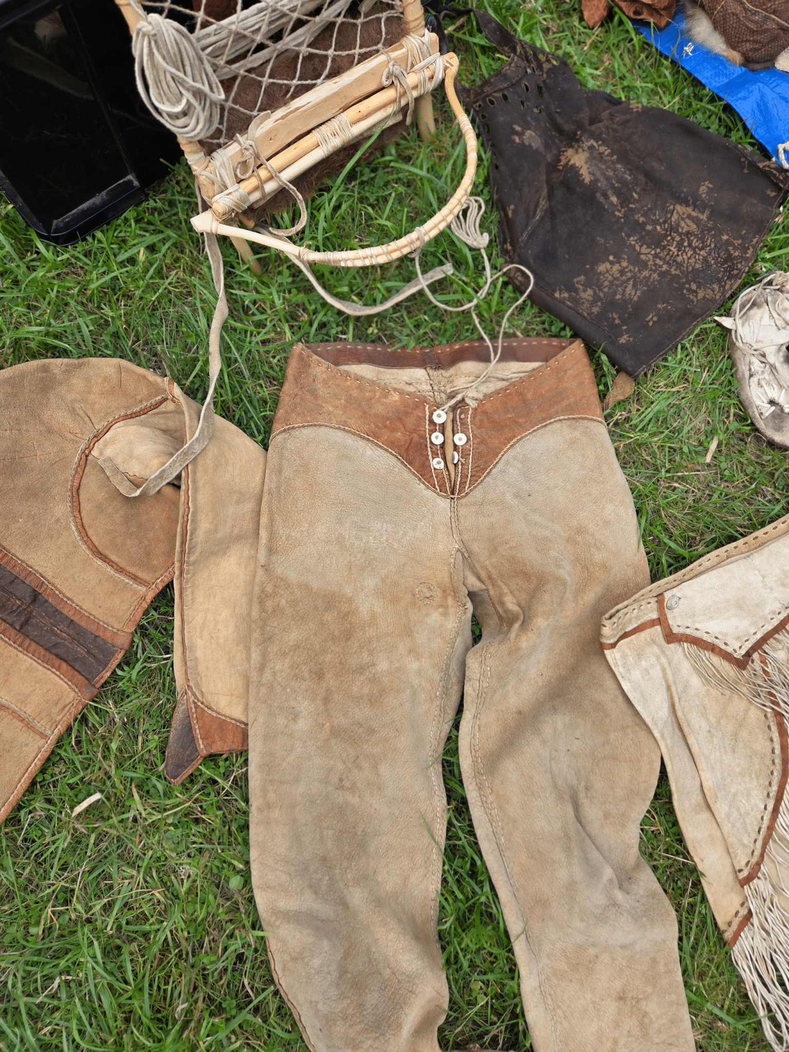 a display of a range of hand made hand stitched leather items including trousers, shirts and tops