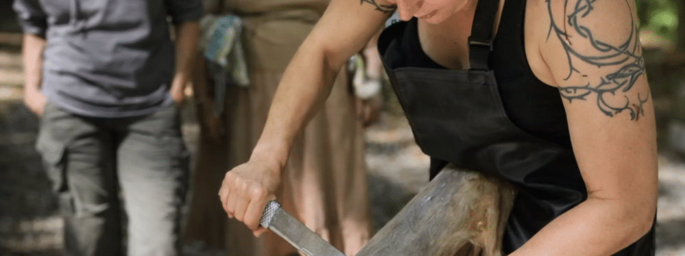 Theresa using an adapted draw knife to degrain the hide
