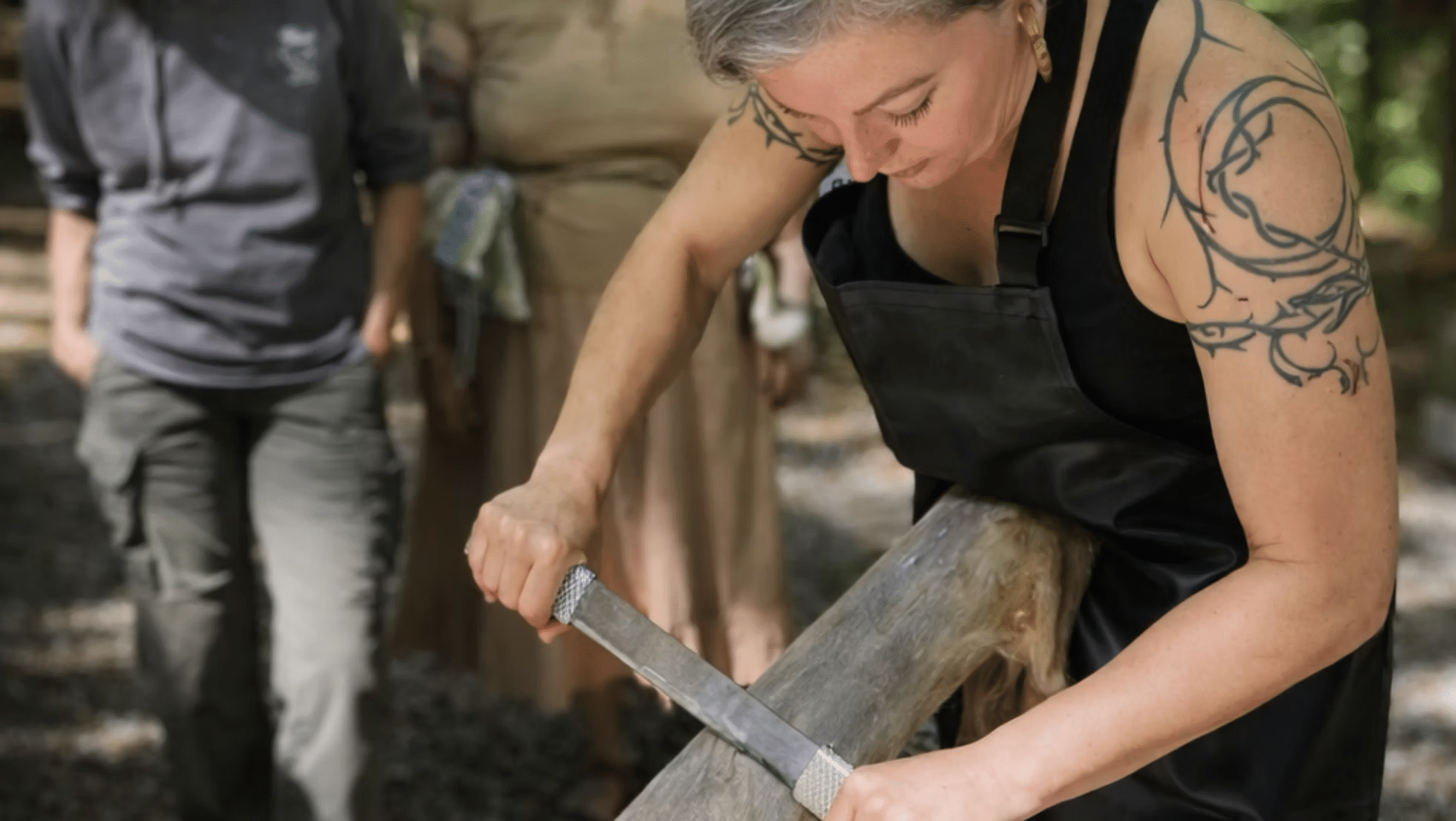 Theresa using an adapted draw knife to degrain the hide